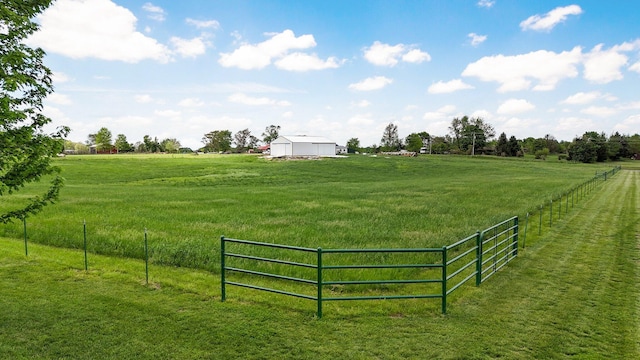 surrounding community with a lawn, a rural view, and fence