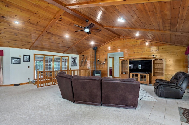 carpeted living area with a ceiling fan, wood ceiling, wood walls, lofted ceiling with beams, and a wood stove