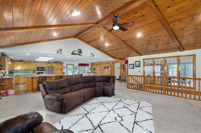 living room featuring beamed ceiling, wood ceiling, light carpet, and a ceiling fan