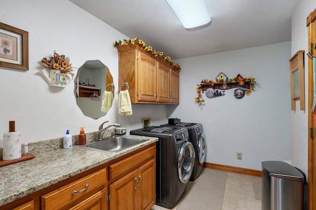 laundry area featuring a sink, baseboards, cabinet space, and washer and dryer