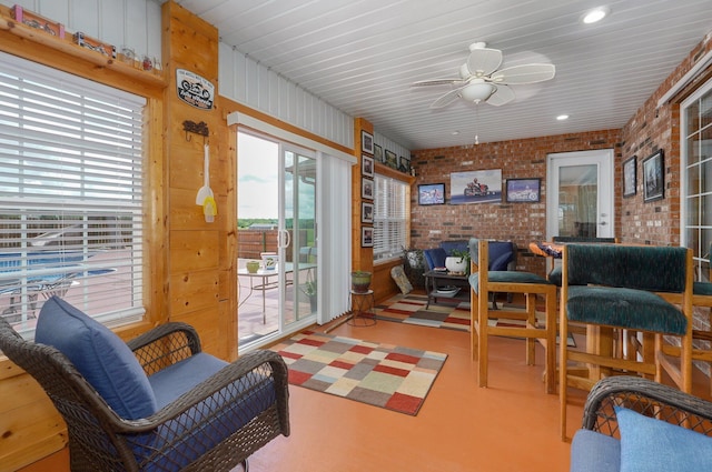 sunroom featuring recessed lighting and brick wall