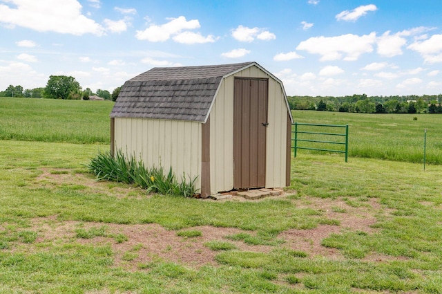 view of shed featuring a rural view and fence