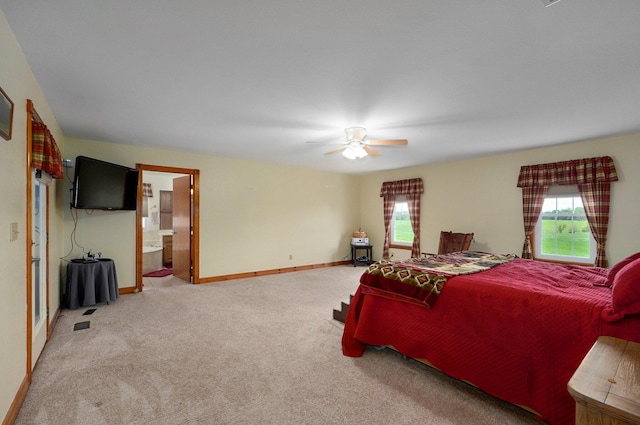 bedroom featuring baseboards, carpet flooring, ensuite bath, and a ceiling fan