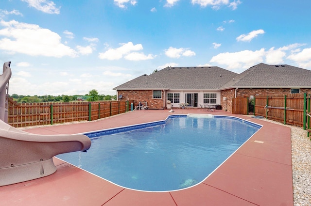 view of pool featuring a patio area, a fenced in pool, a water slide, and a fenced backyard