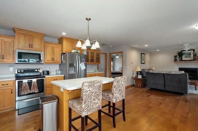 kitchen with light wood-type flooring, light countertops, a chandelier, and appliances with stainless steel finishes