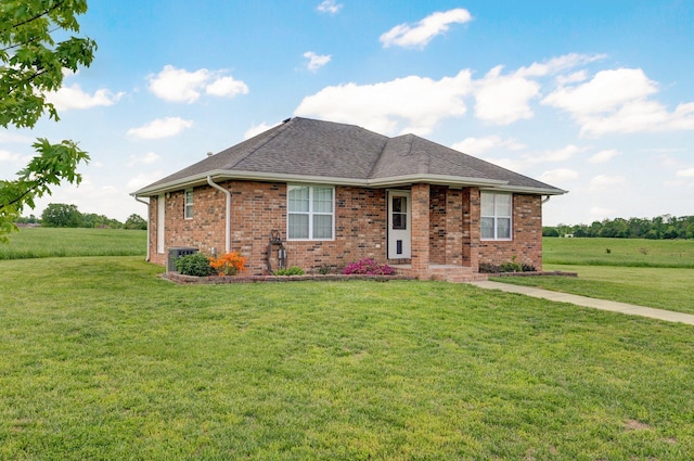 single story home with brick siding, cooling unit, a shingled roof, and a front lawn