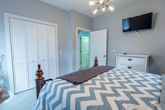 bedroom with light colored carpet, a closet, and a chandelier