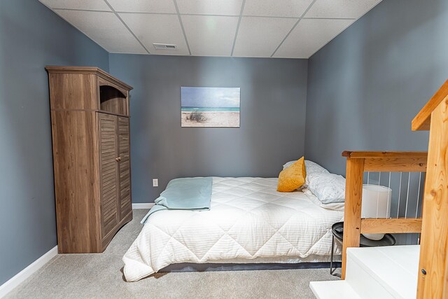 bedroom with carpet flooring, a paneled ceiling, and baseboards