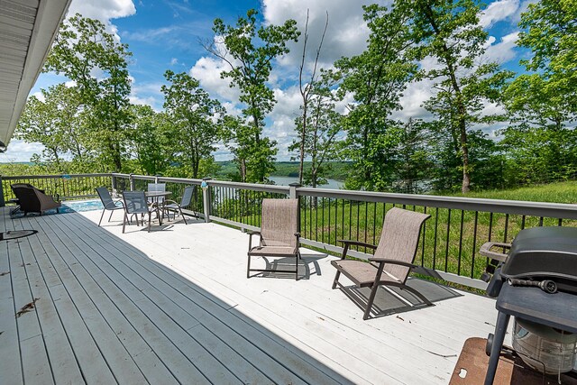wooden terrace with outdoor dining space and a water view