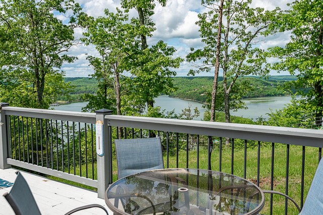 balcony featuring a water view and outdoor dining space