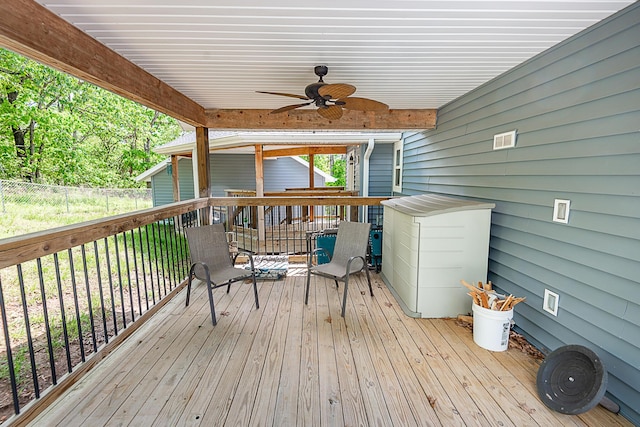 wooden terrace with a ceiling fan and fence