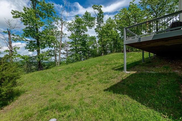 view of green lawn with a wooden deck