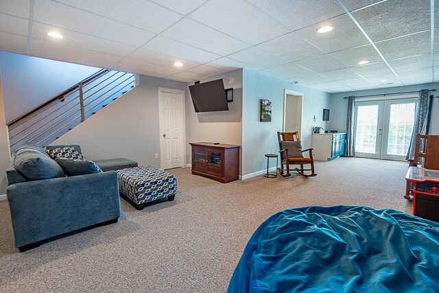 carpeted living area with a drop ceiling, french doors, stairs, recessed lighting, and baseboards