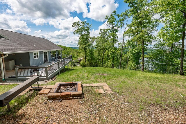 view of yard with an outdoor fire pit and a deck