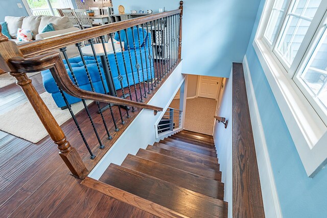 stairs featuring wood finished floors and baseboards