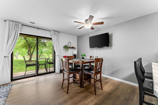 dining area featuring baseboards, ceiling fan, wood finished floors, and visible vents