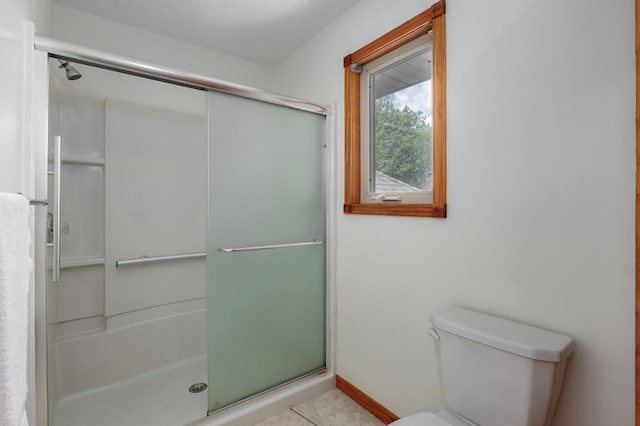 bathroom with tile patterned flooring, a stall shower, and toilet