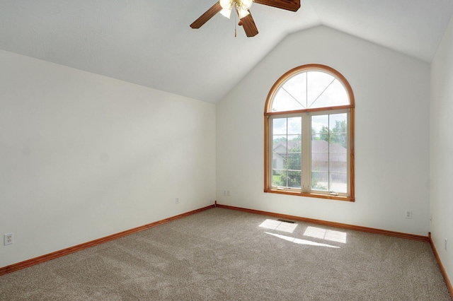 carpeted spare room with baseboards, ceiling fan, and vaulted ceiling