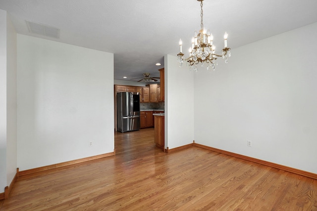unfurnished dining area featuring visible vents, light wood finished floors, and baseboards