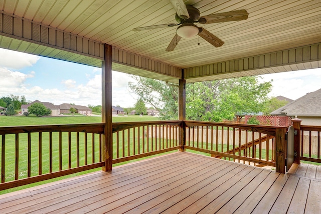 wooden deck with a residential view, ceiling fan, and a yard