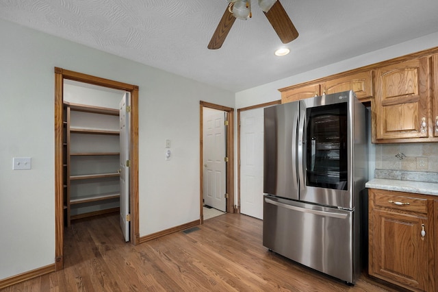 kitchen with wood finished floors, baseboards, smart refrigerator, light countertops, and a ceiling fan