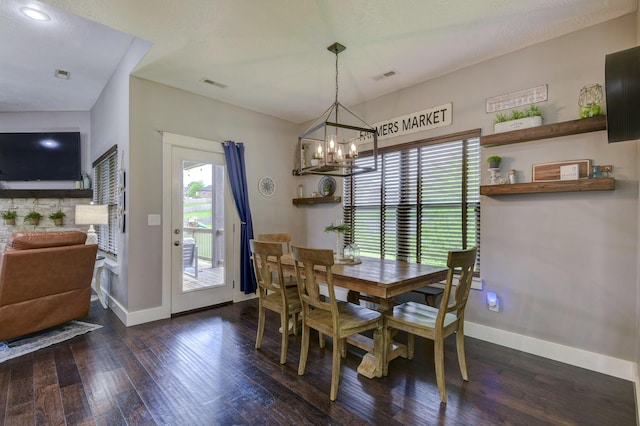 dining area with visible vents, baseboards, wood finished floors, and an inviting chandelier
