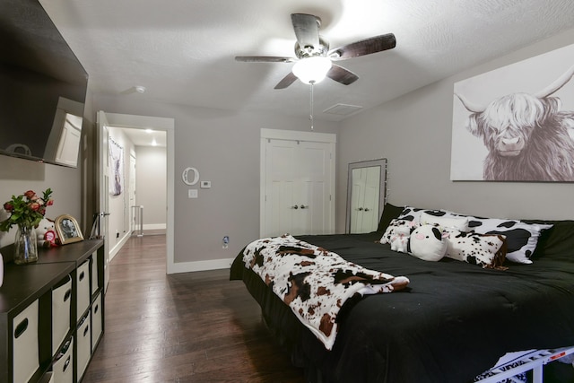 bedroom with visible vents, a closet, dark wood-style flooring, baseboards, and a ceiling fan