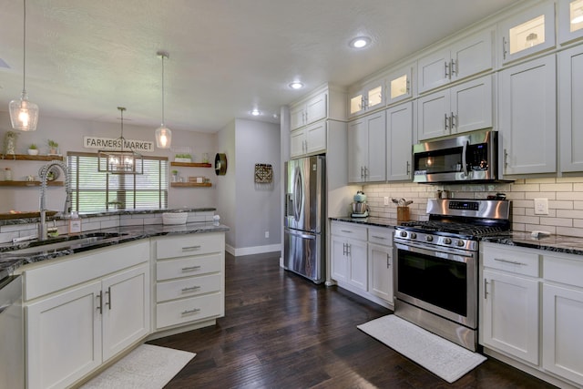 kitchen with a sink, white cabinets, tasteful backsplash, and stainless steel appliances