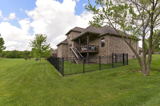rear view of property with fence, a lawn, roof with shingles, and brick siding