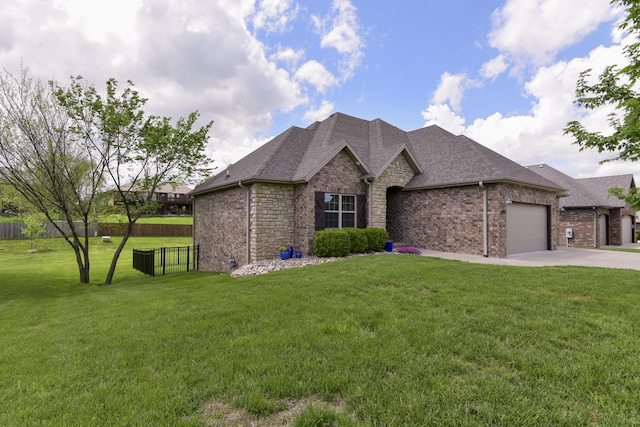 ranch-style house featuring roof with shingles, a front yard, fence, concrete driveway, and an attached garage