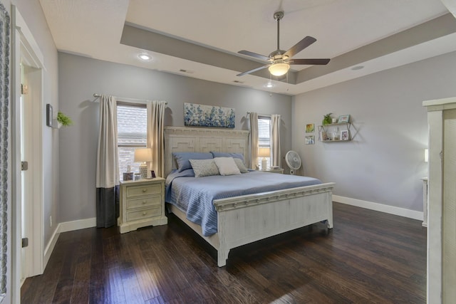 bedroom with baseboards, recessed lighting, dark wood finished floors, and a raised ceiling