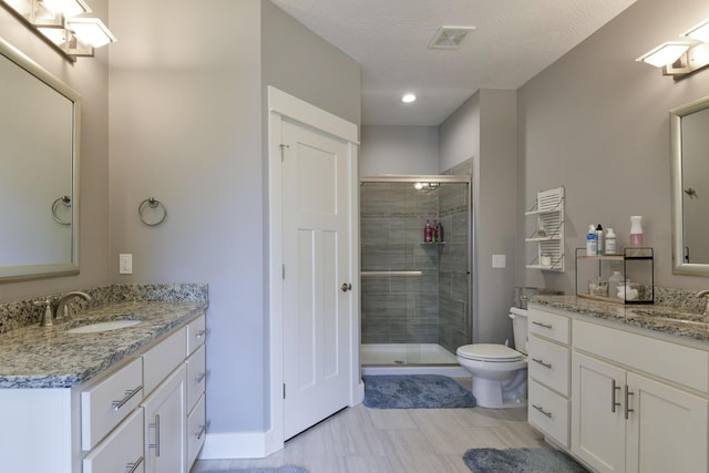bathroom with a sink, a stall shower, and two vanities