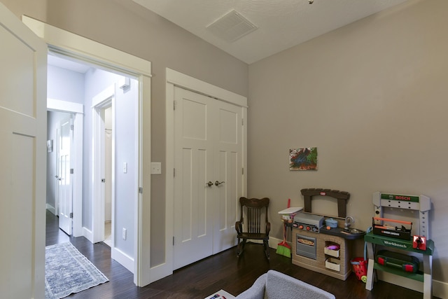game room featuring baseboards, wood finished floors, and visible vents