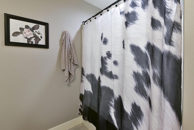 full bathroom featuring baseboards and curtained shower