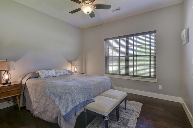 bedroom featuring baseboards, ceiling fan, wood finished floors, and visible vents
