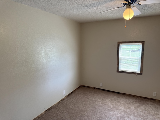 spare room with baseboards, a ceiling fan, a textured ceiling, and light carpet