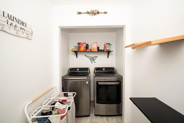 laundry room with independent washer and dryer, light wood-style floors, and laundry area