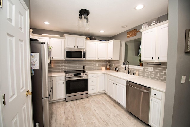 kitchen featuring a sink, decorative backsplash, white cabinets, and appliances with stainless steel finishes