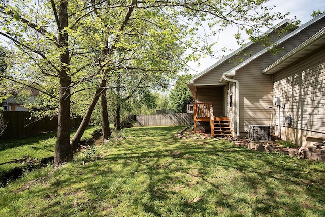 view of yard featuring central air condition unit and fence