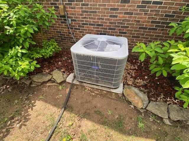 details featuring cooling unit and brick siding