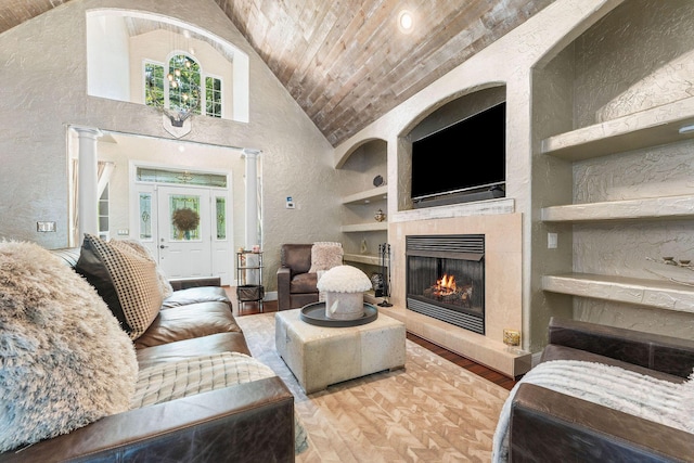 190 Windy Ridge Dr, Hollister, MO 65672 - living area with high vaulted ceiling, built in shelves, a textured wall, a lit fireplace, and wood ceiling