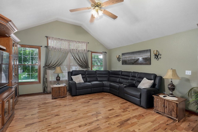 living room featuring a ceiling fan, lofted ceiling, and light wood-style flooring