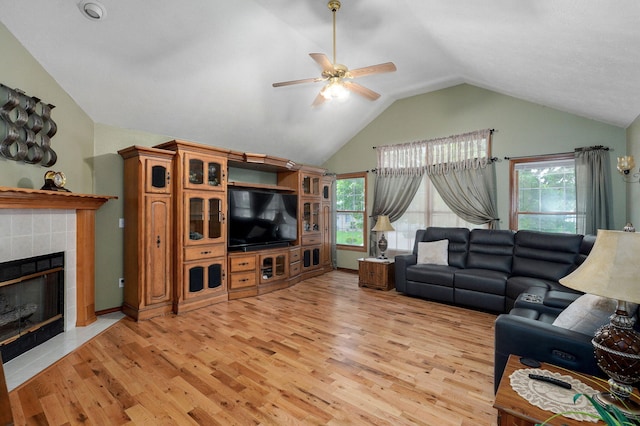 living area featuring a fireplace, a wealth of natural light, light wood-type flooring, ceiling fan, and lofted ceiling
