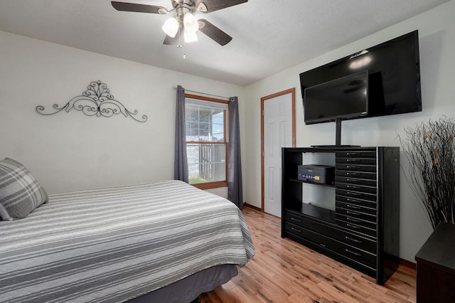 bedroom featuring ceiling fan, baseboards, and light wood-style floors