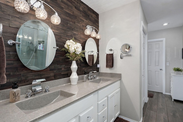bathroom featuring double vanity, wooden walls, baseboards, and a sink