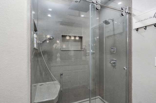 full bathroom featuring a shower stall and a textured wall