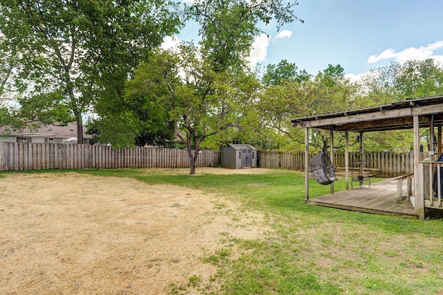 view of yard featuring a storage shed, an outdoor structure, a wooden deck, and a fenced backyard