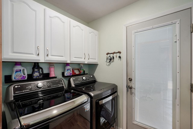laundry room featuring washing machine and clothes dryer and cabinet space