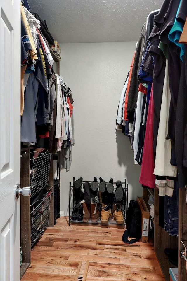 walk in closet with wood finished floors