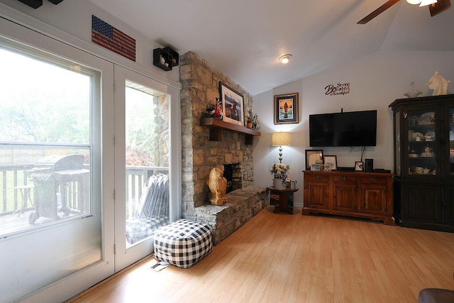 living room with a ceiling fan, wood finished floors, lofted ceiling, and a healthy amount of sunlight
